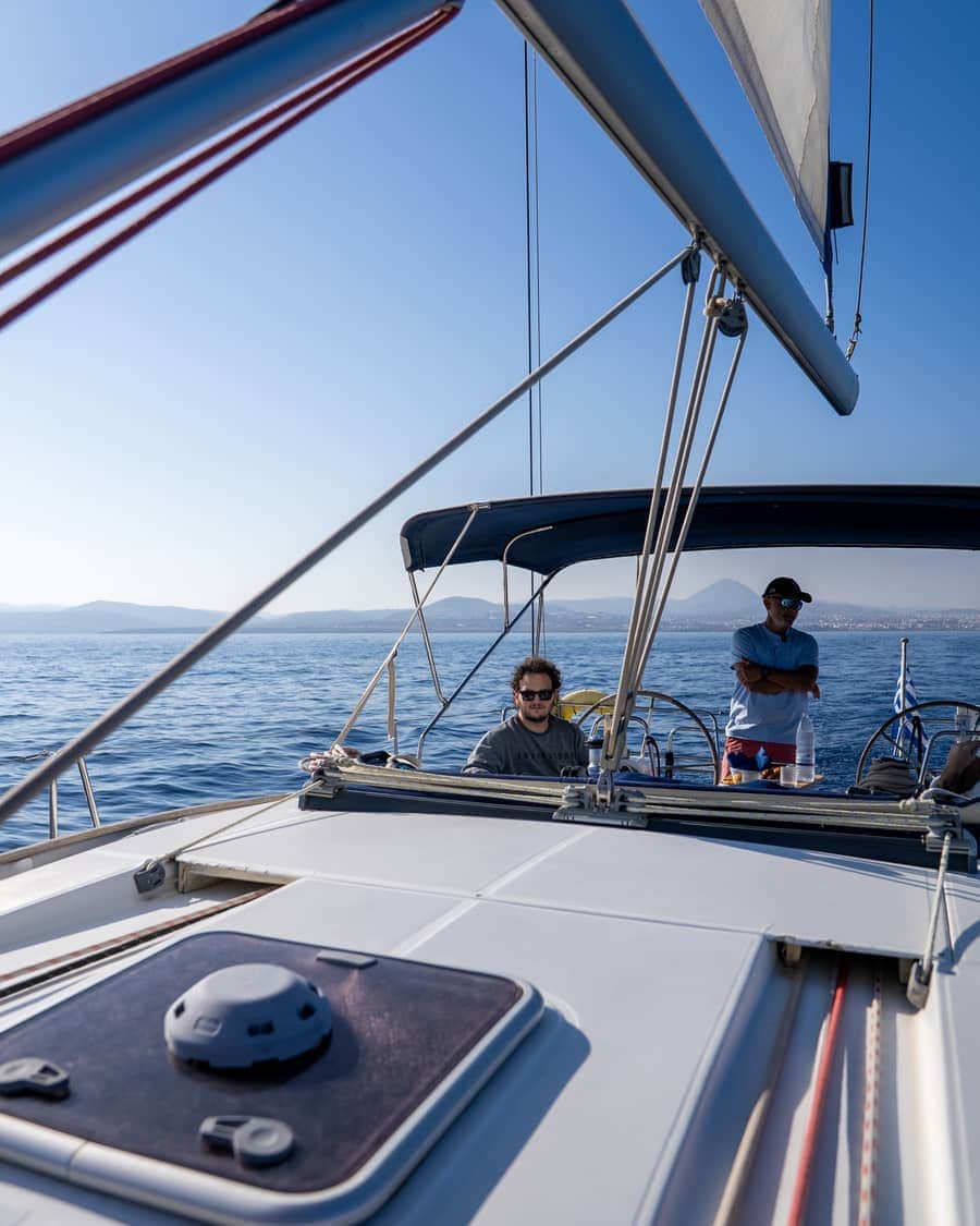 Skipper and guests at the helm of a private sailing yacht in Crete